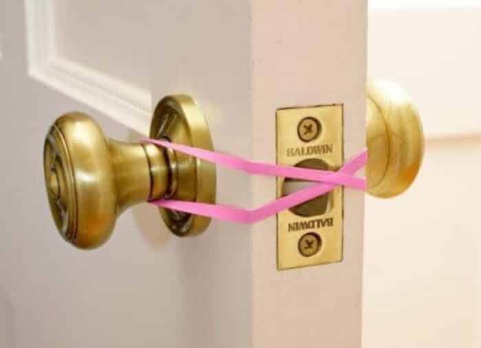 picture of a rubber band tied across a door handle