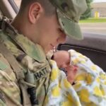 Guardia militar cargando en sus brazos a una bebé