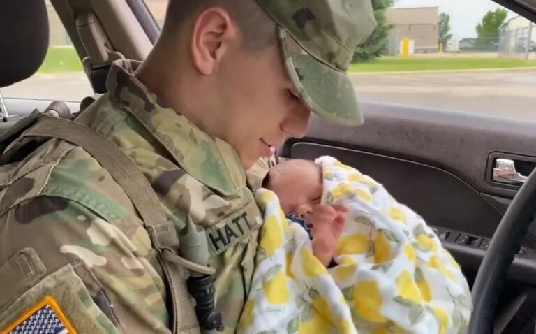 Guardia militar cargando en sus brazos a una bebé